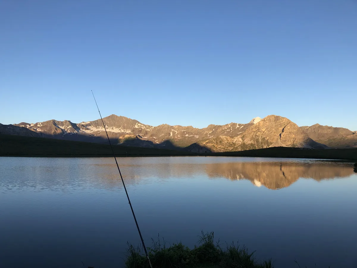 Canne à pêche posée au bord du lac de l'Ouillette au lever du jour