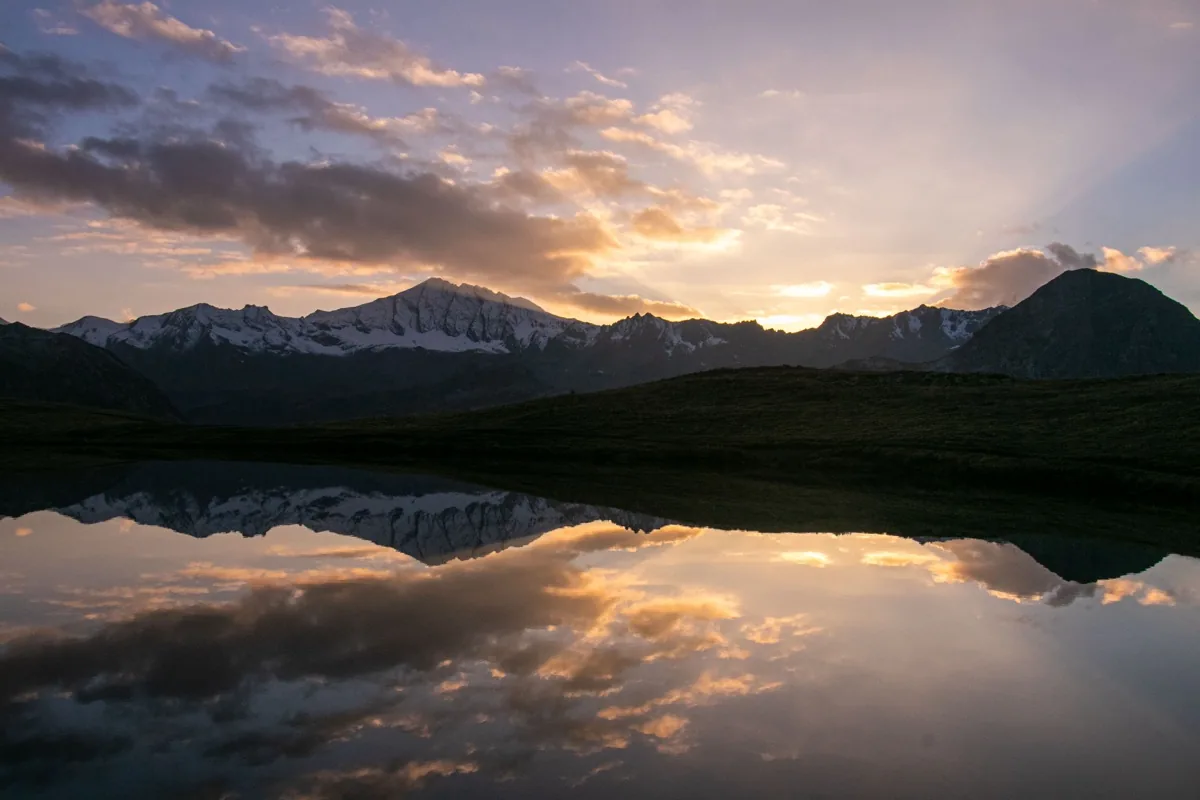 Coucher de soleil sur le lac de l'Ouillette, sommets enneigés se reflétant dans l'eau