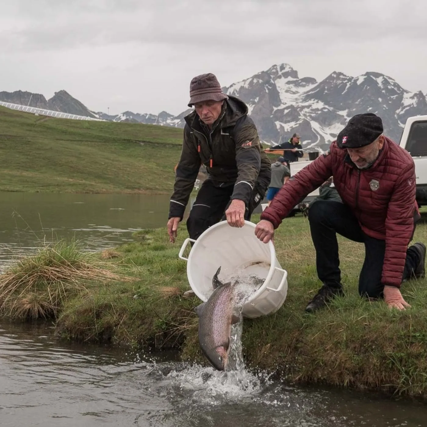 Deux sociétaires du Groupe Sportif relâchent une truite arc-en-ciel dans le lac