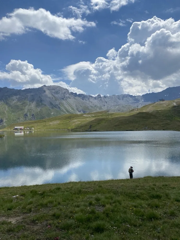 Pêcheur seul au bord du lac, cumulus dramatiques en arrière-plan