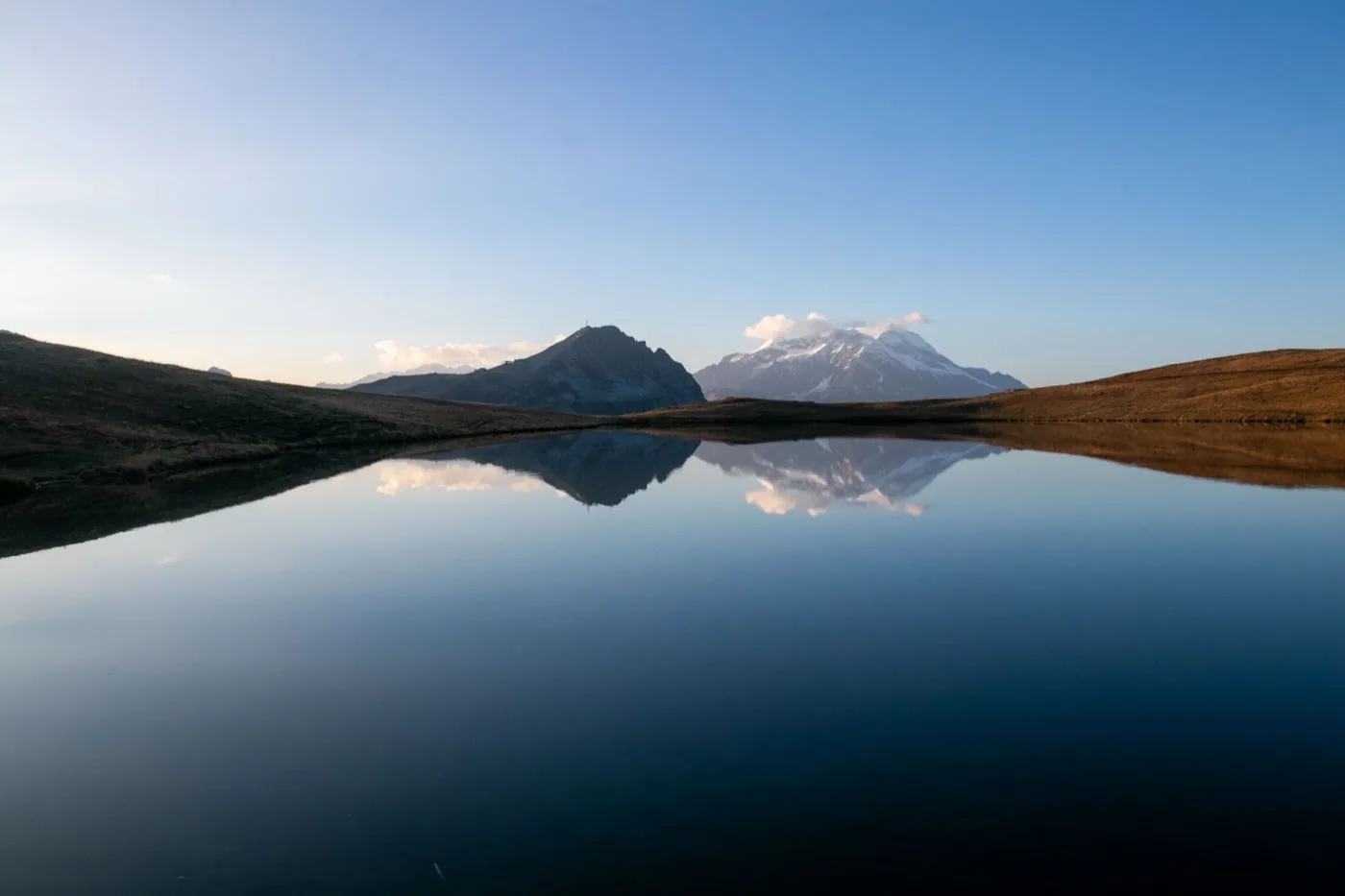 Sommets de la Vanoise reflétés dans l'eau calme du lac de l'Ouillette au coucher du soleil